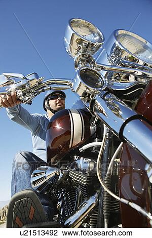 Biker riding motorcycle, low angle view View Large Photo Image Stock Image - Biker riding motorcycle, low angle view. Fotosearch