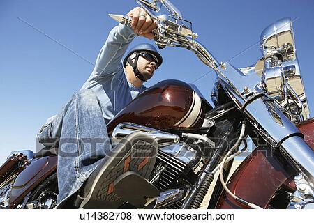 Biker riding motorcycle, low angle view View Large Photo Image Stock Photo - Biker riding motorcycle, low angle view. Fotosearch