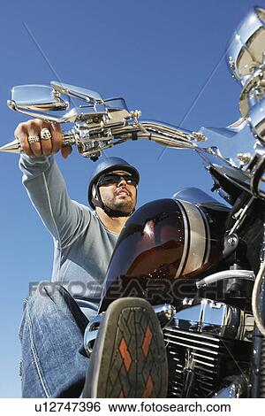 Biker riding motorcycle, low angle view View Large Photo Image Stock Photograph - Biker riding motorcycle, low angle view. Fotosearch