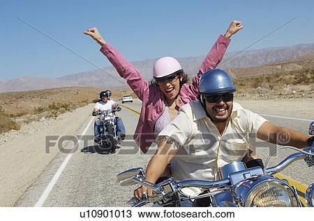 Stock Image - Bikers riding on desert road. Fotosearch