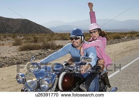 Stock Image - Bikers riding on desert road. Fotosearch