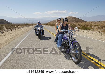 Stock Photo - Bikers riding on desert road. Fotosearch