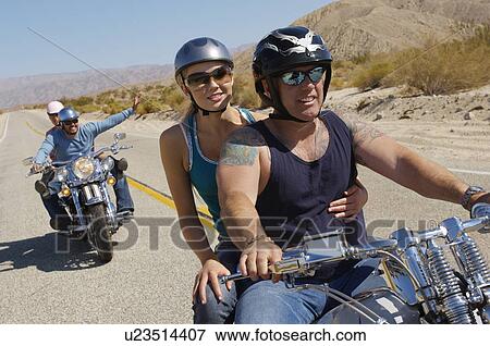 Stock Photo - Bikers riding on desert road. Fotosearch