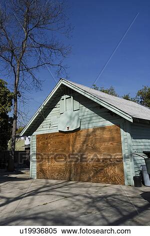 Stock Photography - Boarded Up Garage of Empty House. Fotosearch