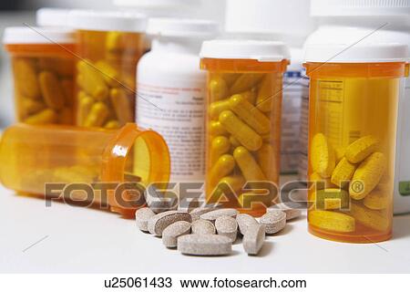Bottles of pills, one spilling, close-up View Large Photo Image Stock Image - Bottles of pills, one spilling, close-up. Fotosearch