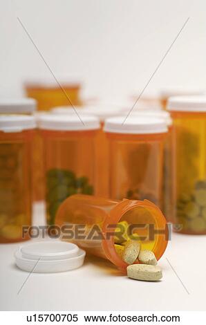 Stock Photography - Bottles of pills, one spilling, close-up. Fotosearch