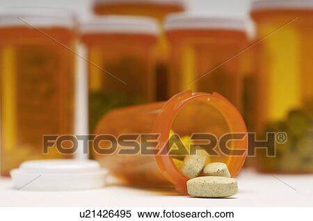Stock Photography - Bottles of pills, one spilling, close-up. Fotosearch