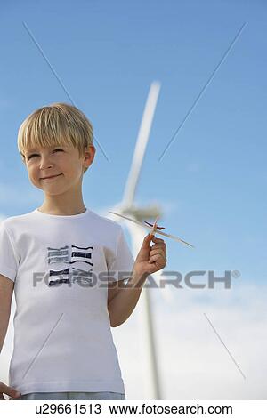 Boy (7-9) playing with toy glider at wind farm View Large Photo Image Stock Image - Boy (7-9) playing with toy glider at wind farm. Fotosearch