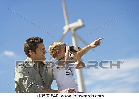 Boy (7-9) using binoculars with father at wind farm View Large Photo Image Stock Image - Boy (7-9) using binoculars with father at wind farm. Fotosearch