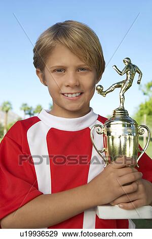 Boy (7-9 years) soccer player holding trophy, portrait View Large Photo Image Stock Photo - Boy (7-9 years) soccer player holding trophy, portrait. Fotosearch
