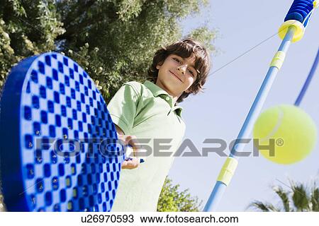 Stock Image - Boy Playing with Paddle and Tethered Ball. Fotosearch