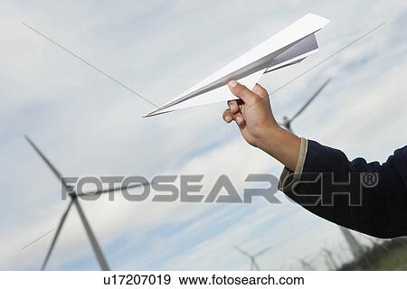 Boys hand throwing paper plane at wind farm, close-up View Large Photo Image Stock Photo - Boys hand throwing paper plane at wind farm, close-up. Fotosearch