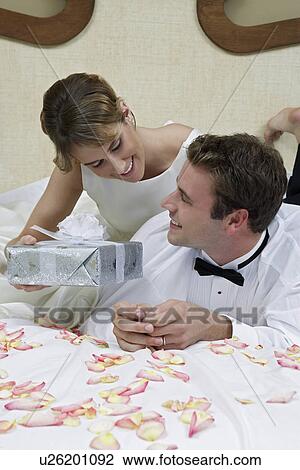 Bride and groom relaxing on bed among presents, portrait View Large Photo Image Stock Image - Bride and groom relaxing on bed among presents, portrait. Fotosearch