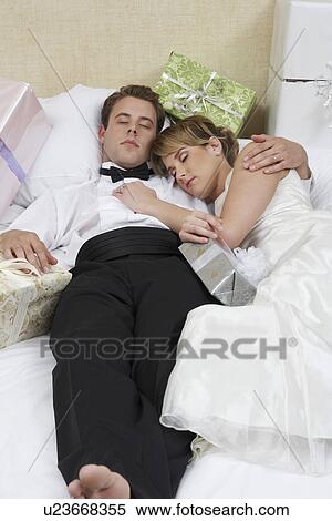 Stock Photography - Bride and groom sleeping among presents. Fotosearch