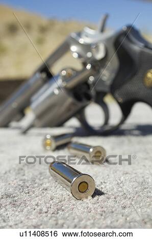 Stock Photograph - Bullets beside gun, close-up. Fotosearch