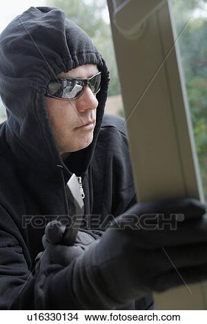 Picture - Burglar breaking into house. Fotosearch