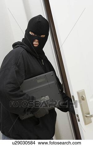 Picture - Burglar stealing laptop. Fotosearch
