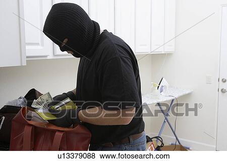 Stock Photo - Burglar stealing money from house, close-up. Fotosearch