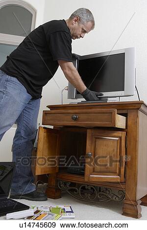 Burglar stealing television in house View Large Photo Image Stock Photo - Burglar stealing television in house. Fotosearch