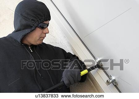 Burglar using crowbar to break into house View Large Photo Image Stock Image - Burglar using crowbar to break into house. Fotosearch