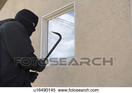 Stock Photography - Burglar using crowbar to break into house. Fotosearch