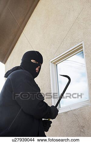 Burglar using crowbar to get into house View Large Photo Image Picture - Burglar using crowbar to get into house. Fotosearch