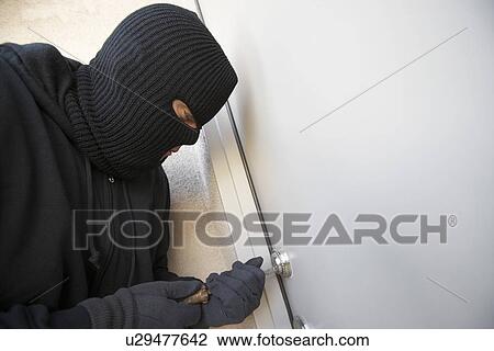 Burglar working on lock of front door View Large Photo Image Stock Image - Burglar working on lock of front door. Fotosearch