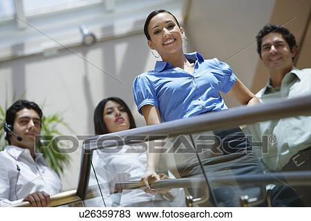 Stock Image - Business colleagues standing on stairs. Fotosearch