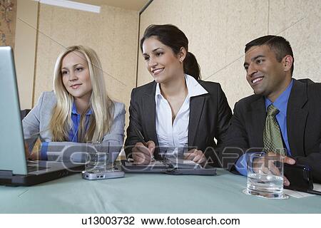 Business colleagues using laptop at conference meeting View Large Photo Image Stock Image - Business colleagues using laptop at conference meeting. Fotosearch