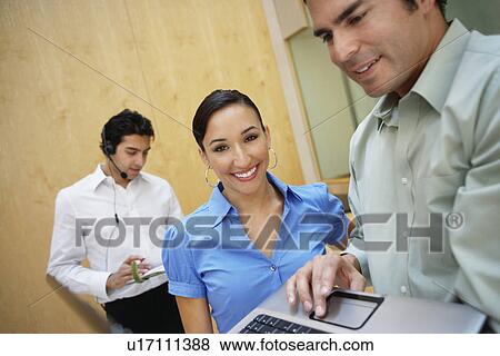 Stock Photo - Business colleagues working in office. Fotosearch
