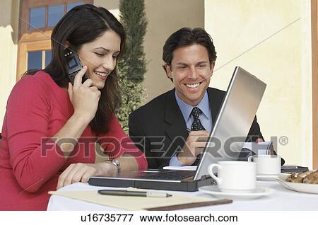 Stock Photo - Business man and woman sitting at outdoor cafe table. Fotosearch