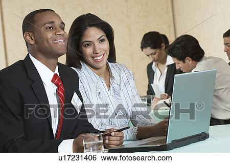 Business man and woman using laptop at conference meeting View Large Photo Image Stock Photograph - Business man and woman using laptop at conference meeting. Fotosearch