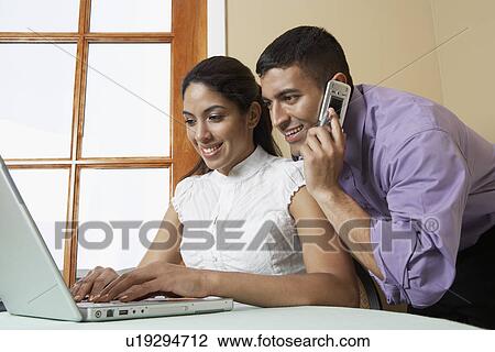 Business man and woman working with laptop at desk in office View Large Photo Image Stock Image - Business man and woman working with laptop at desk in office. Fotosearch