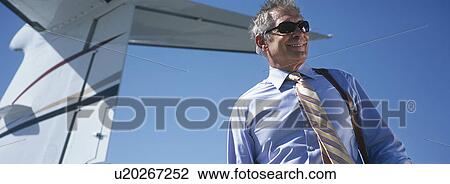 Business man by tail of private plane View Large Photo Image Stock Image - Business man by tail of private plane. Fotosearch