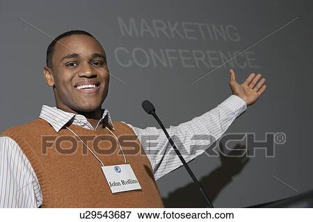 Stock Photo - Business man giving presentation at conference meeting, portrait. Fotosearch