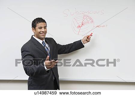 Stock Photo - Business man giving presentation standing at whiteboard. Fotosearch