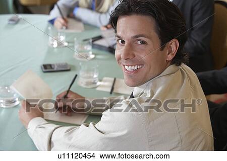 Business man writing at conference meeting, portrait View Large Photo Image Picture - Business man writing at conference meeting, portrait. Fotosearch