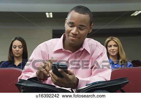 Business people sitting in auditorium View Large Photo Image Stock Image - Business people sitting in auditorium. Fotosearch