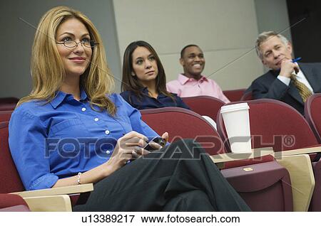 Business people sitting in auditorium View Large Photo Image Stock Photo - Business people sitting in auditorium. Fotosearch