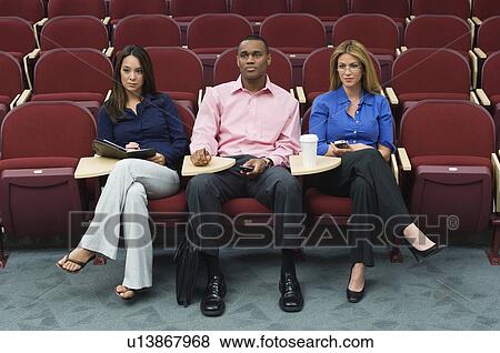 Stock Photo - Business people sitting in auditorium. Fotosearch
