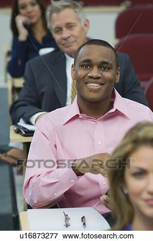 Stock Photo - Business people sitting in auditorium. Fotosearch