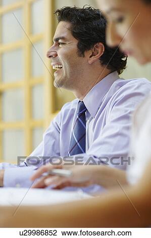 Stock Image - Business people sitting in meeting. Fotosearch