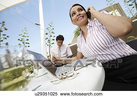 Stock Photography - Business woman and business man working outdoors. Fotosearch