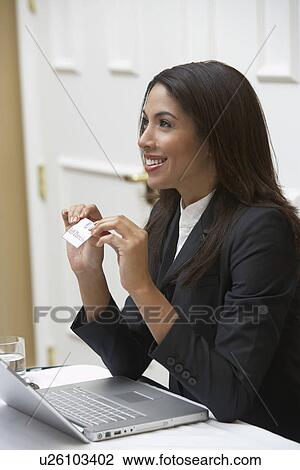 Stock Image - Business woman offering name tag in office. Fotosearch