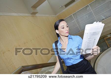 Business woman reading newspaper on staircase View Large Photo Image Stock Photo - Business woman reading newspaper on staircase. Fotosearch