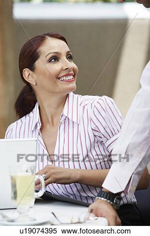 Stock Photography - Business woman smiling, with colleague. Fotosearch