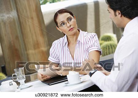 Stock Image - Business woman talking to colleague. Fotosearch