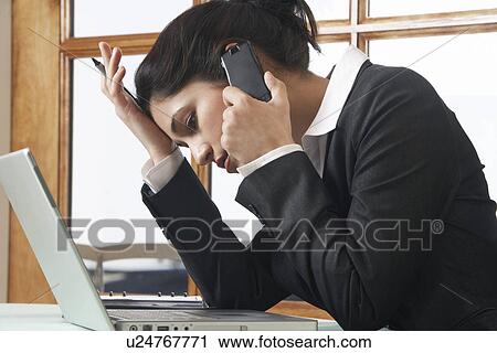 Business woman using mobile phone at desk in office View Large Photo Image Stock Image - Business woman using mobile phone at desk in office. Fotosearch