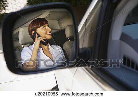 Stock Photography - Business woman using mobile phone in car. Fotosearch