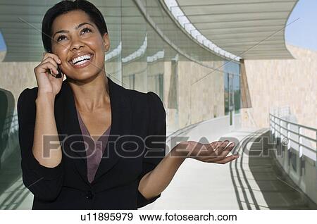 Business woman using mobile phone standing outside office building View Large Photo Image Stock Photo - Business woman using mobile phone standing outside office building. Fotosearch